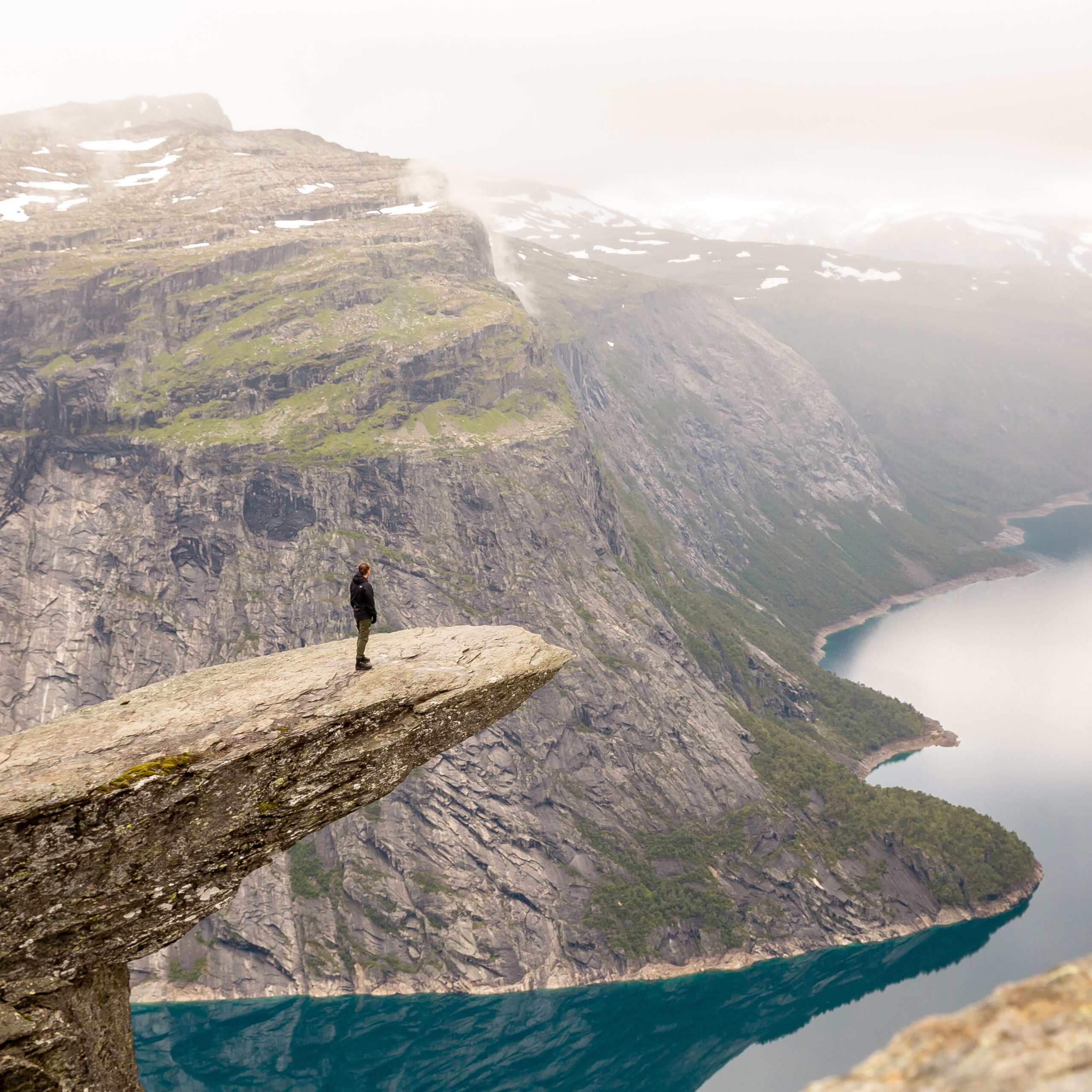 Photograph of someone standing on a hill overlooking a mountain range