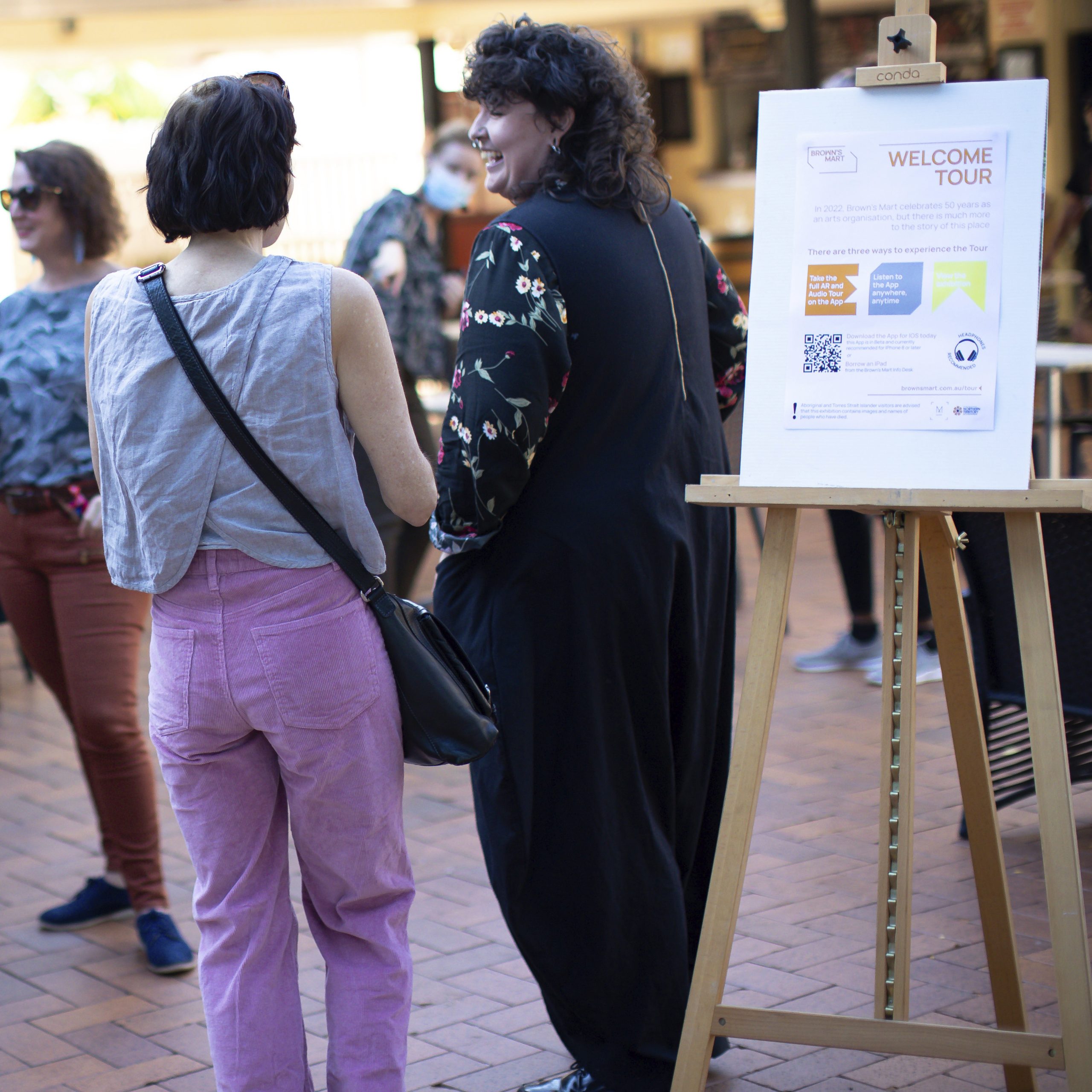 Photograph of people standing around courtyard talking
