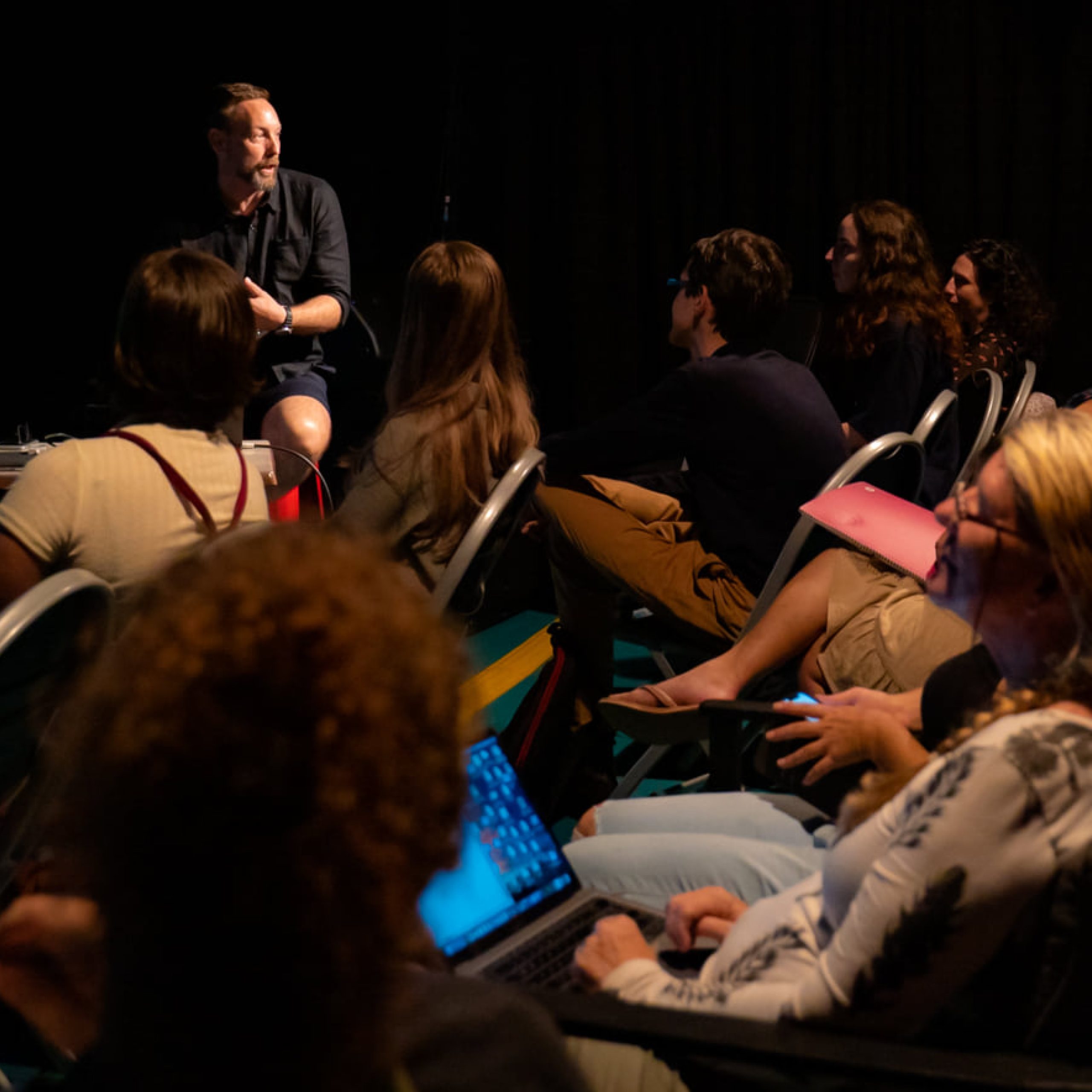 Photograph of a room of people watching someone speak at a workshop int he Brown's Mart Studio