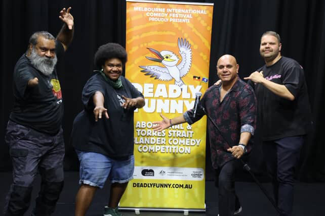 Photograph fo 4 people standing in front of a banner