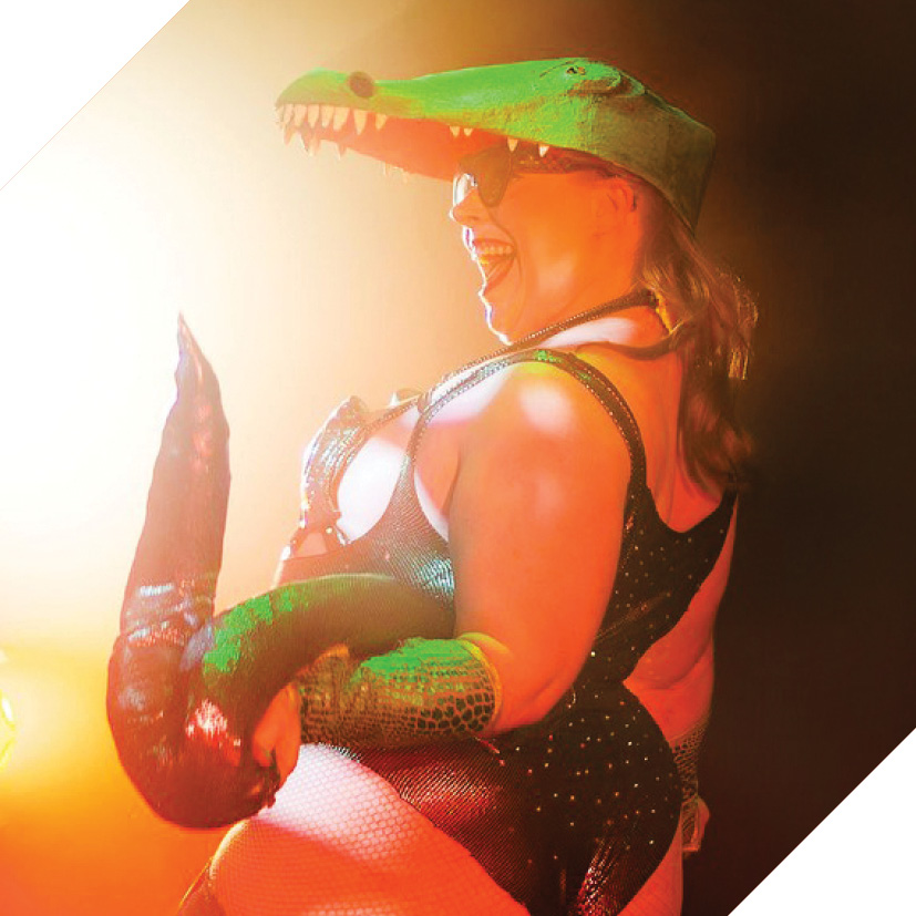 Photograph of performer Millie Divine dressed as a crocodile