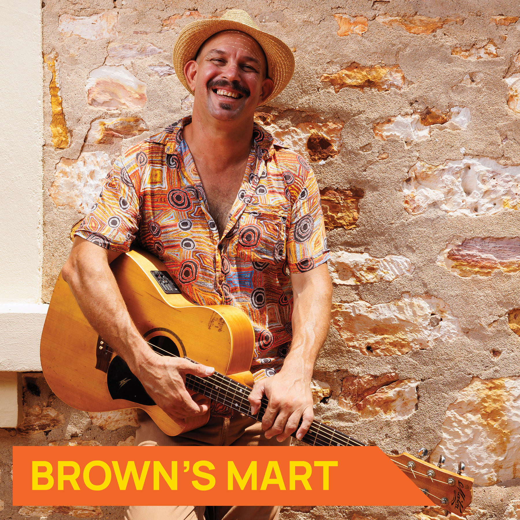 Photograph of musician David Spry holding a guitar and smiling