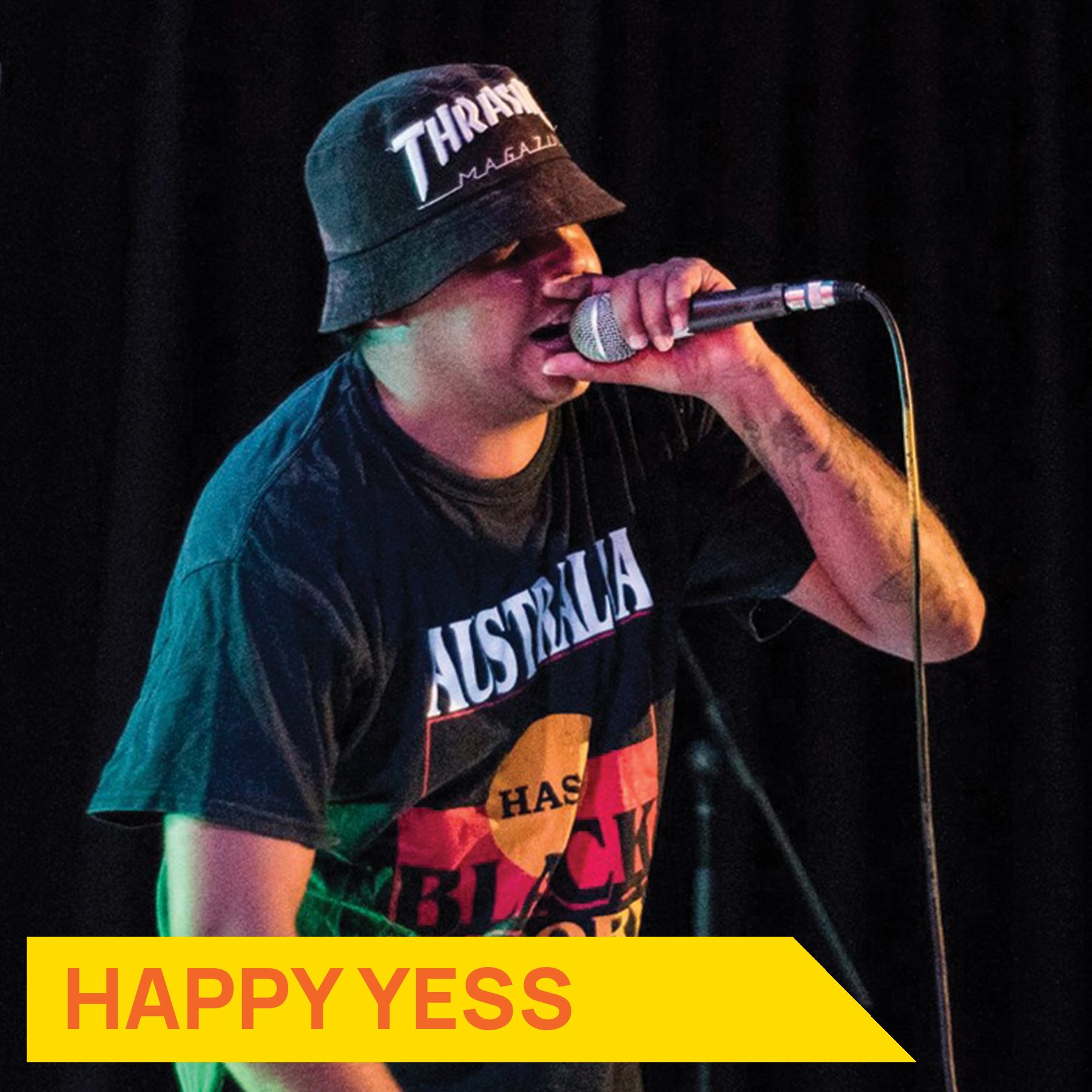 Artist holding up a microphone and rapping with text saying "Happy Yess"
